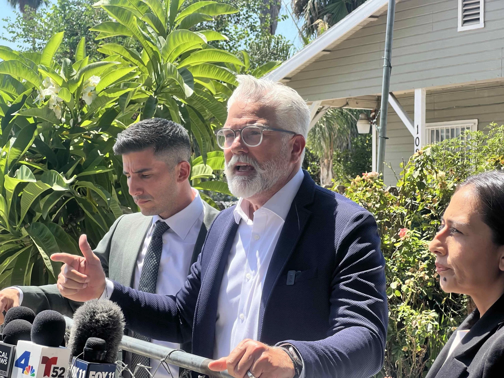 Attorney Jason Sanchez, center, joined by his colleagues Robbie Muñoz and Cynthia Santiago at a press conference held outside of Francisco Longoria's home. Longoria says his truck was shot at by federal immigration agents last week and wants answers. Sanchez, Muñoz and Santiago want city and county officials to investigate the shooting.